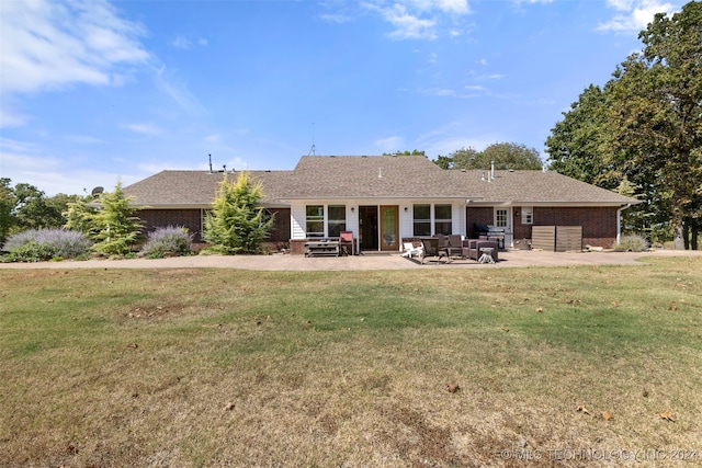 rear view of house with a patio and a lawn