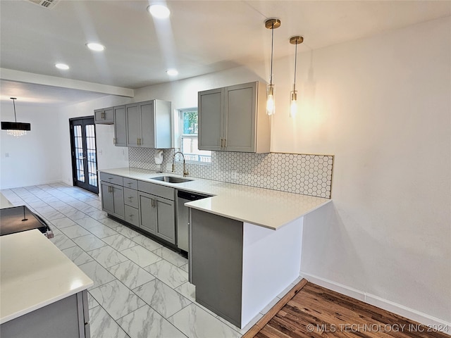 kitchen with gray cabinetry, hanging light fixtures, sink, and dishwasher