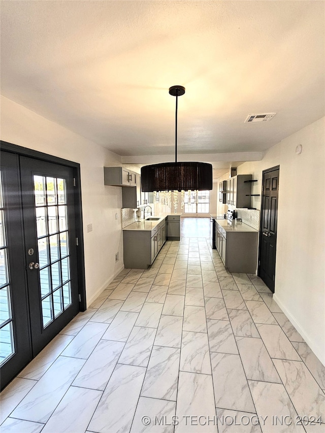 2532 N Martin Luther King Jr Blvd, Tulsa, OK 74106 - kitchen featuring a sink, baseboards, light marble finish flooring, and light countertops