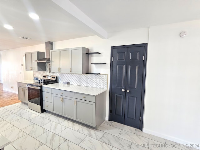 kitchen featuring wall chimney range hood, gray cabinets, beamed ceiling, tasteful backsplash, and stainless steel range with electric stovetop