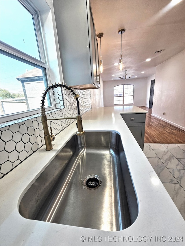 2532 N Martin Luther King Jr Blvd, Tulsa, OK 74106 - kitchen view of a sink, tasteful backsplash, decorative light fixtures, baseboards, and a peninsula