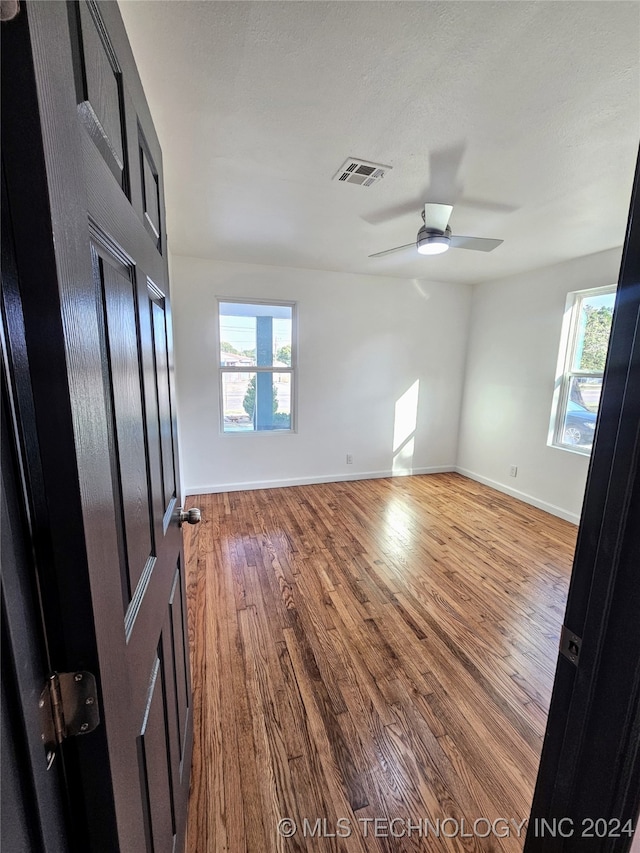 empty room featuring ceiling fan, a textured ceiling, and hardwood / wood-style floors