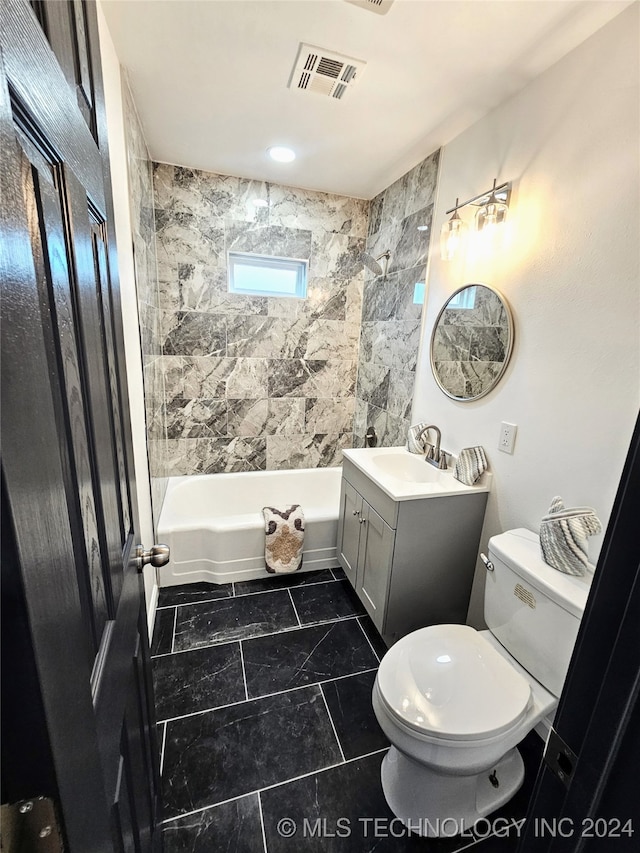 full bathroom featuring toilet, tile patterned floors, tile walls, tiled shower / bath, and vanity