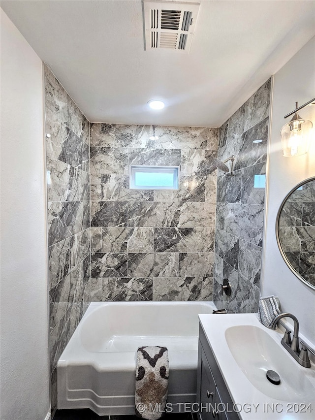 bathroom with vanity and tiled shower / bath