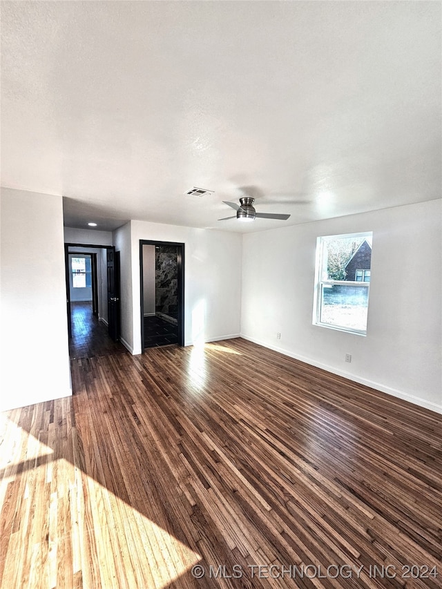 unfurnished living room with dark wood-type flooring and ceiling fan