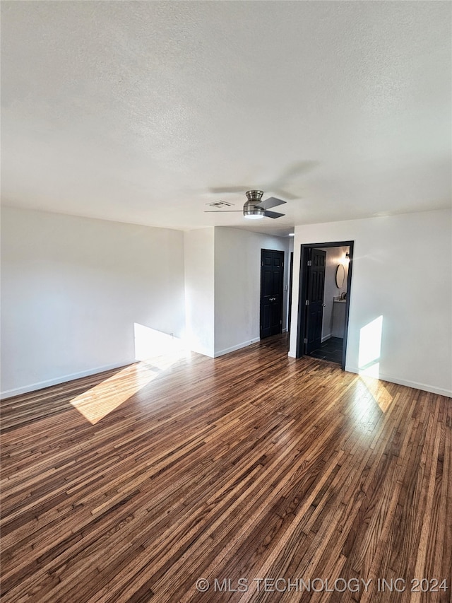 empty room with ceiling fan, a textured ceiling, and dark hardwood / wood-style flooring