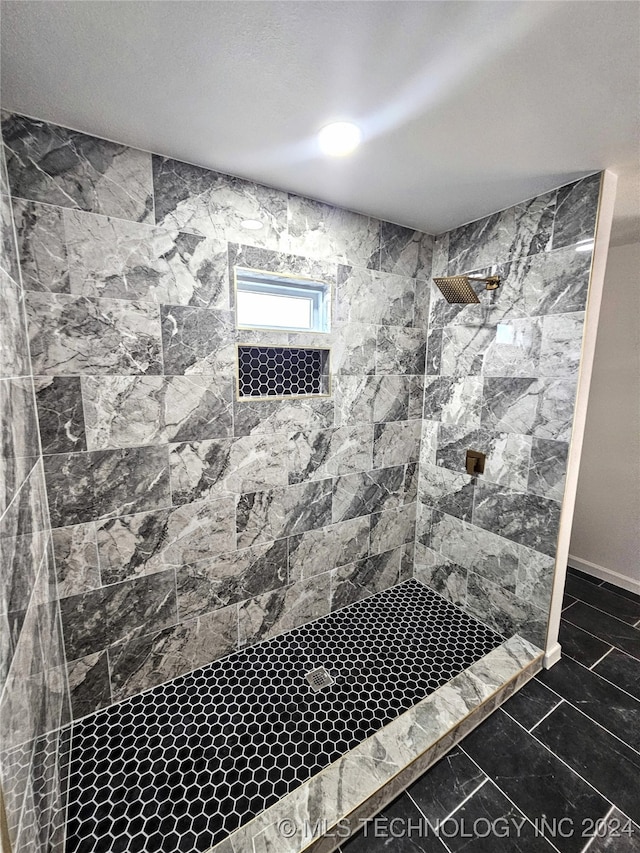 bathroom featuring tiled shower and a textured ceiling