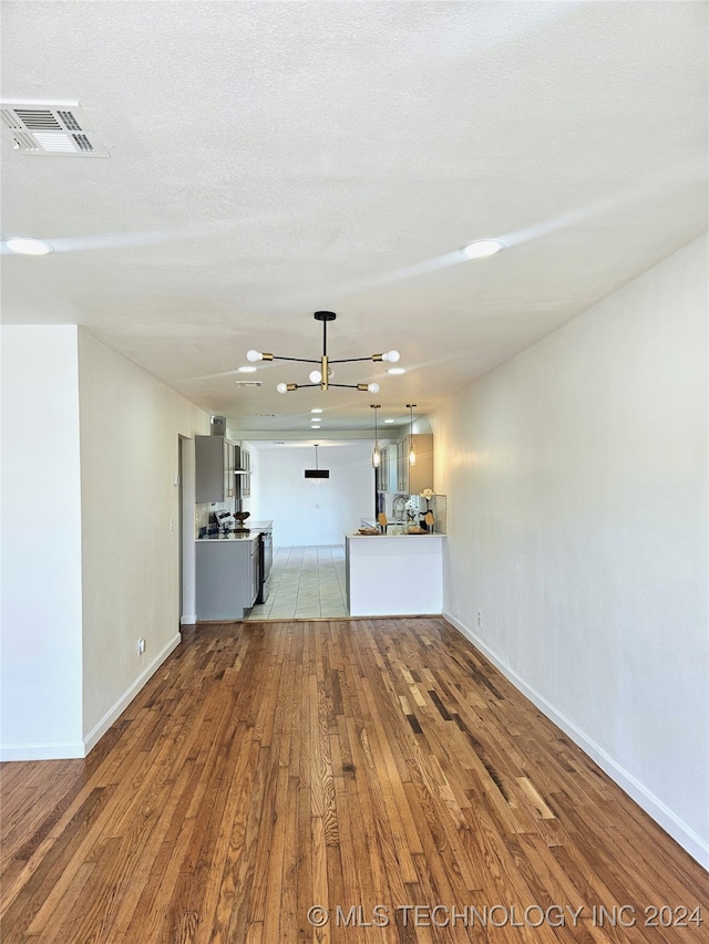 2532 N Martin Luther King Jr Blvd, Tulsa, OK 74106 - unfurnished living room with hardwood / wood-style floors, baseboards, and a chandelier