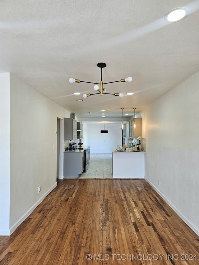 unfurnished living room with a chandelier and light hardwood / wood-style flooring