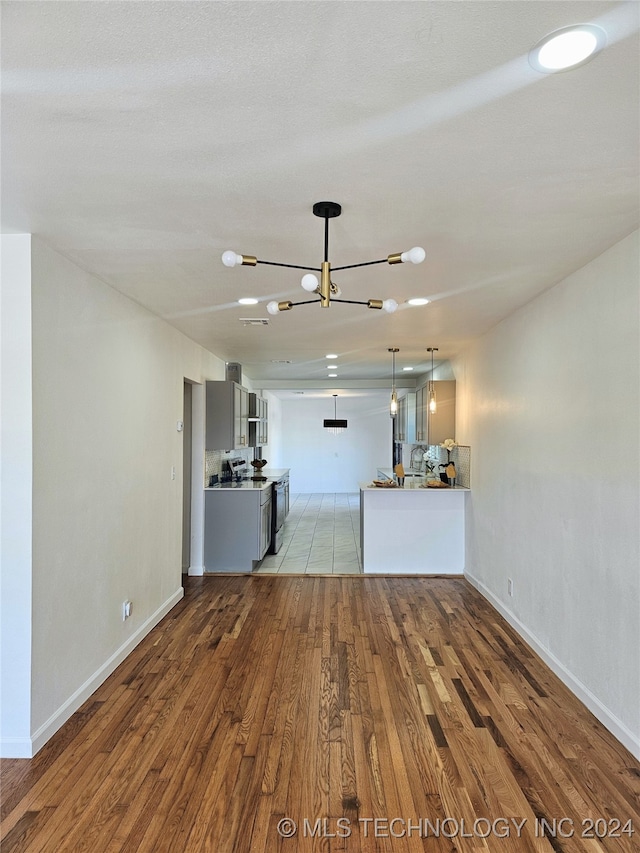 2532 N Martin Luther King Jr Blvd, Tulsa, OK 74106 - unfurnished living room with wood finished floors, a chandelier, and baseboards