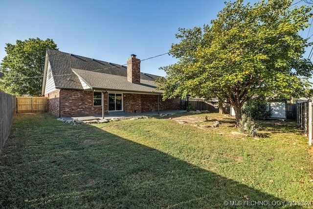 rear view of house with a patio and a yard