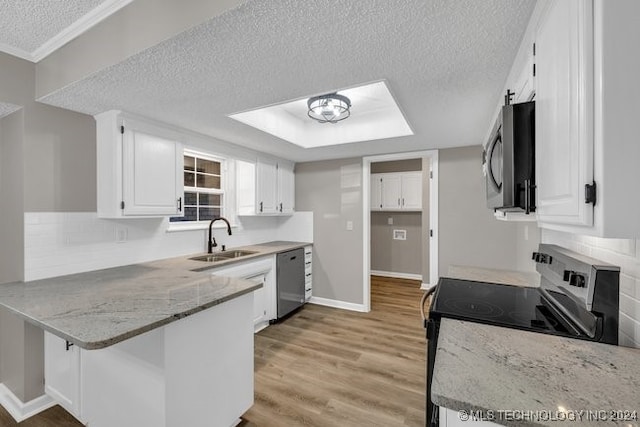 kitchen featuring light stone counters, white cabinets, sink, light hardwood / wood-style flooring, and stainless steel appliances