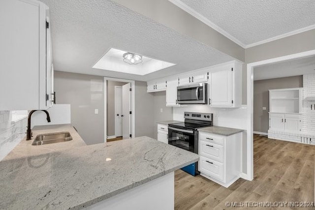 kitchen featuring white cabinets, sink, a textured ceiling, appliances with stainless steel finishes, and light wood-type flooring