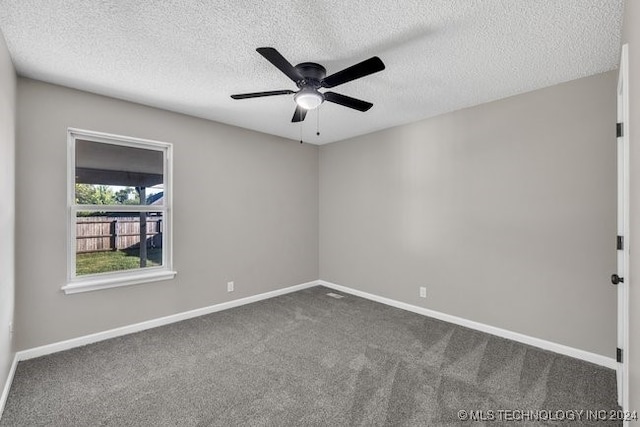 carpeted empty room with ceiling fan and a textured ceiling