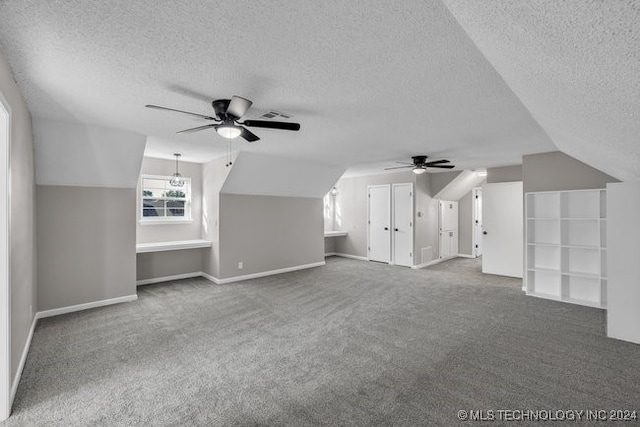 additional living space with a textured ceiling, vaulted ceiling, carpet flooring, and ceiling fan