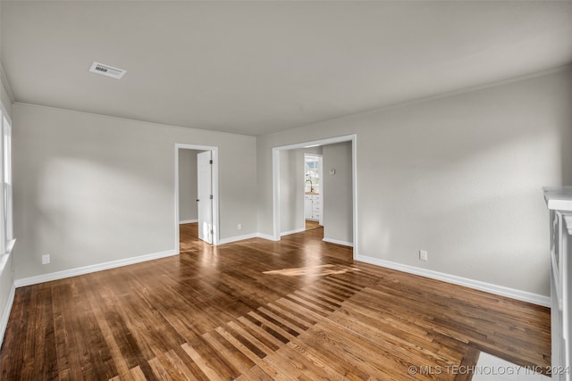 spare room with wood-type flooring and crown molding