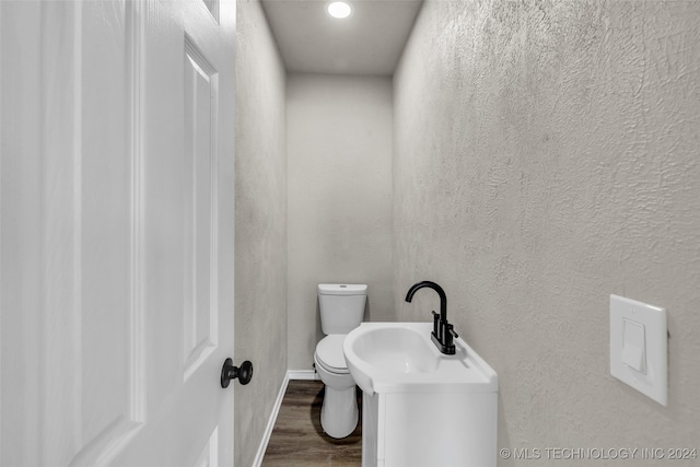 bathroom with wood-type flooring, vanity, and toilet