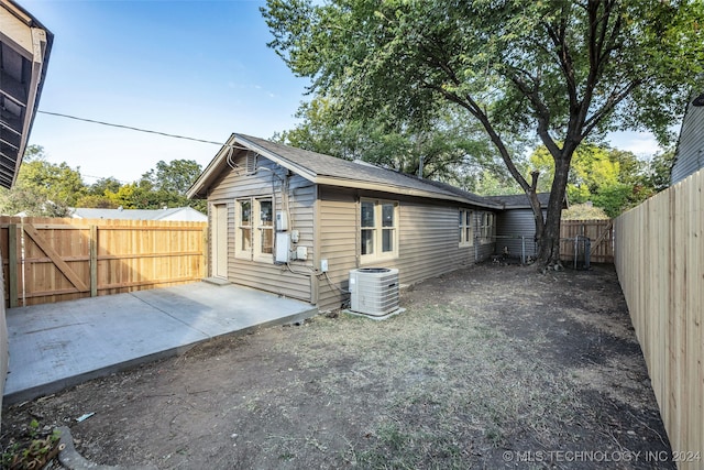 rear view of house with cooling unit and a patio