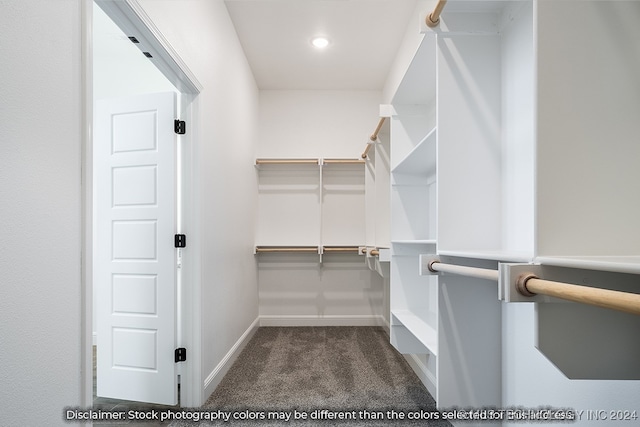 walk in closet featuring dark colored carpet