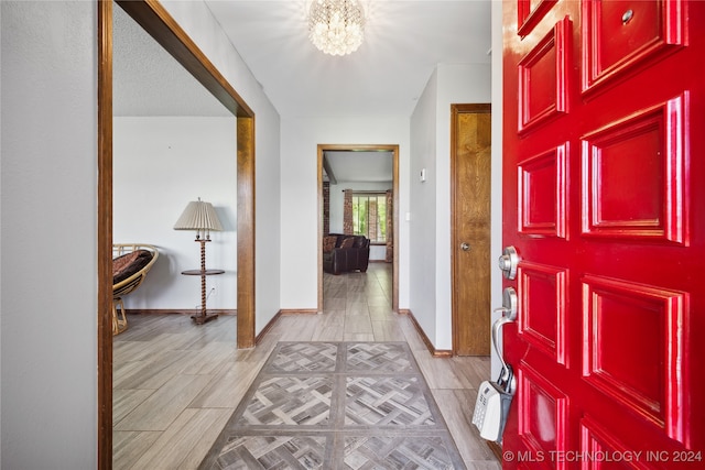 entryway featuring light hardwood / wood-style flooring and a notable chandelier