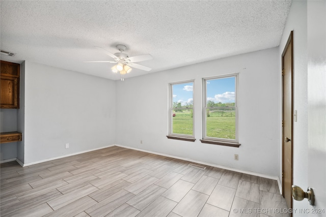 unfurnished room with a textured ceiling and ceiling fan