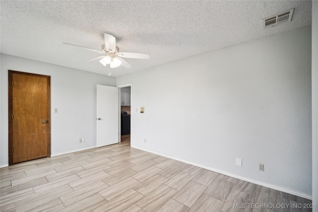 empty room with ceiling fan and a textured ceiling