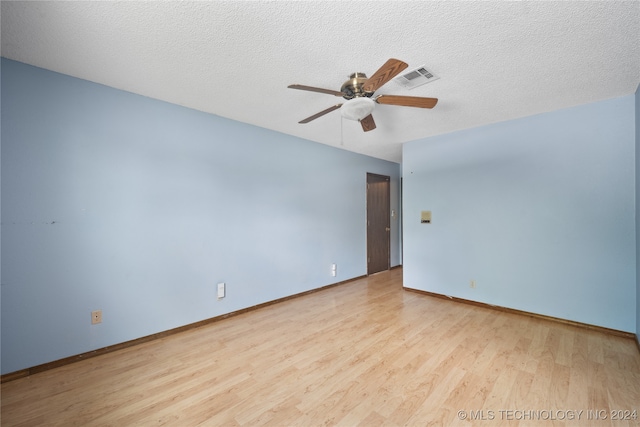 unfurnished room with ceiling fan, light wood-type flooring, and a textured ceiling