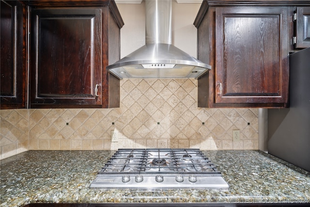 kitchen featuring decorative backsplash, dark brown cabinets, wall chimney exhaust hood, and stainless steel gas stovetop