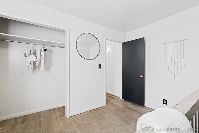 bedroom with ornamental molding, a closet, and hardwood / wood-style floors