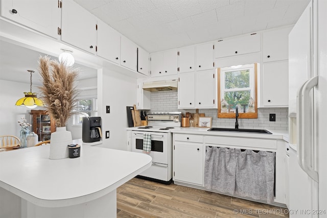 kitchen with hardwood / wood-style floors, premium range hood, white appliances, sink, and white cabinetry