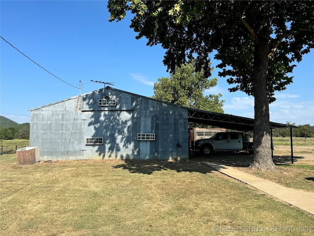 view of outbuilding with central AC unit and a yard