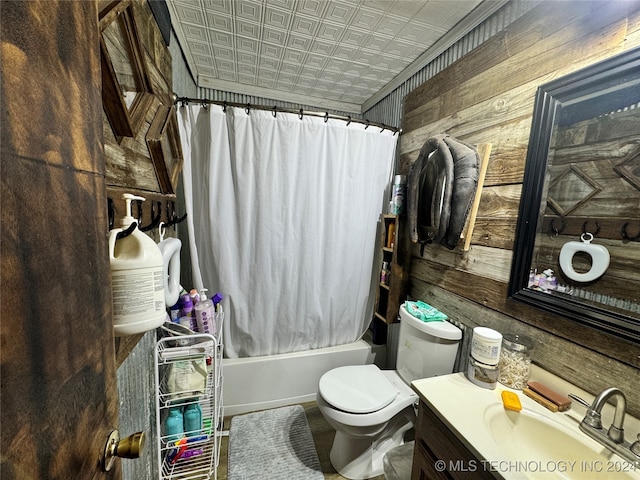 full bathroom with wooden walls, shower / bath combo, vanity, and toilet