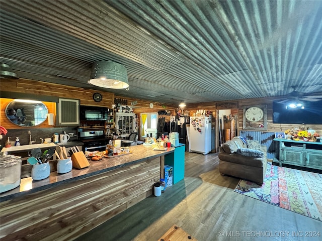 interior space featuring white refrigerator, wood walls, and wood-type flooring