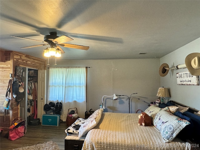 bedroom featuring a textured ceiling, ceiling fan, a closet, and dark hardwood / wood-style flooring