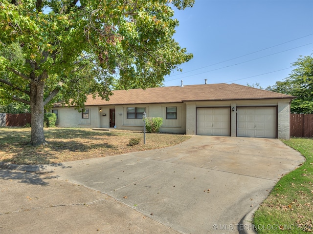 ranch-style home featuring a garage and a front lawn