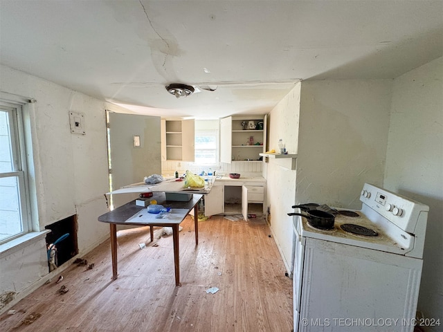 kitchen with built in shelves, white cabinets, light hardwood / wood-style flooring, and white electric stove