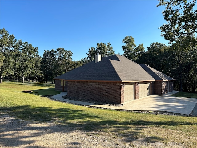 view of side of home with a garage and a lawn