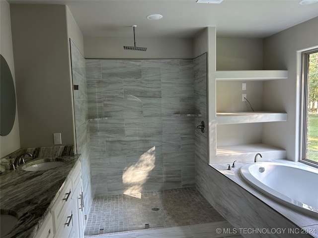 bathroom with vanity, a healthy amount of sunlight, plus walk in shower, and tile patterned flooring