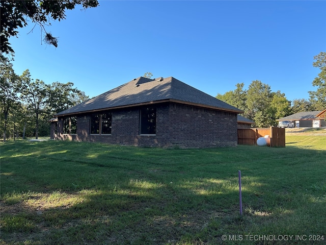 view of side of property featuring a storage shed and a lawn