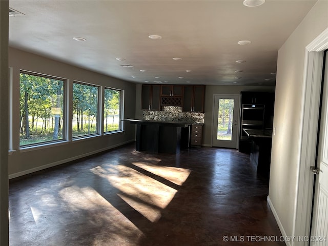 kitchen featuring decorative backsplash, a center island, and double oven