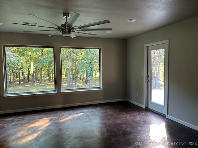 spare room with ceiling fan, a textured ceiling, and plenty of natural light