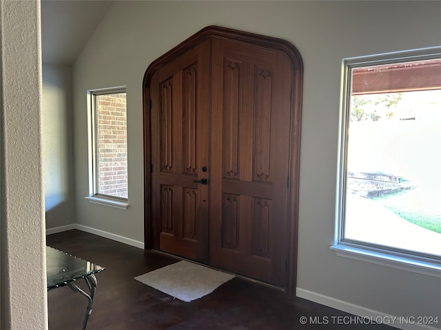 foyer featuring dark wood-type flooring and lofted ceiling