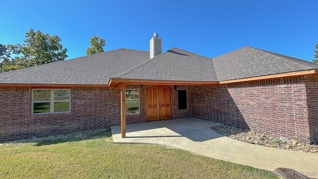 rear view of property featuring a yard and a patio area