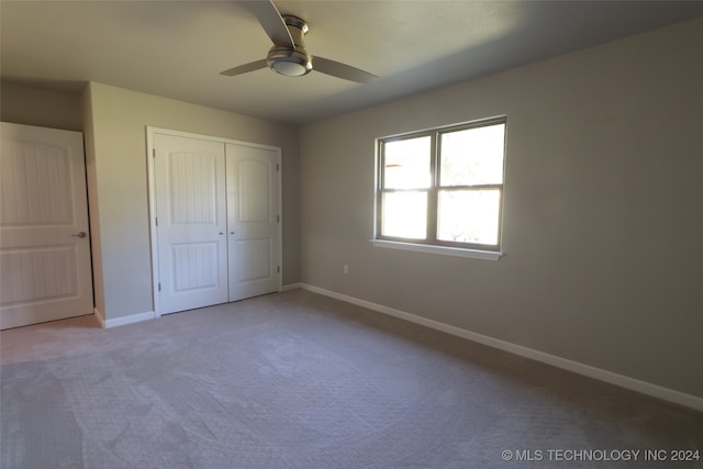 unfurnished bedroom with a closet, carpet flooring, and ceiling fan