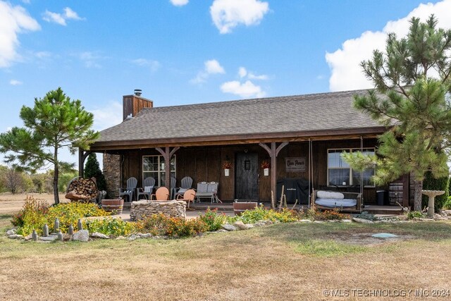 rear view of property featuring a yard and a patio area