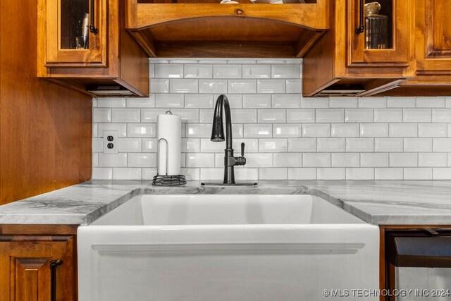 kitchen with light stone counters, sink, and tasteful backsplash