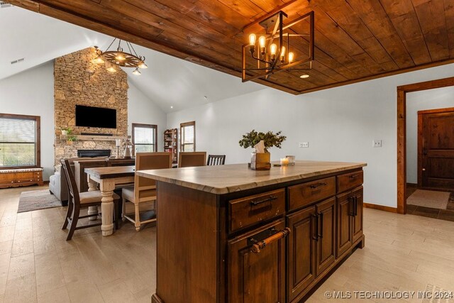 kitchen featuring hanging light fixtures, vaulted ceiling, wooden ceiling, and a kitchen island