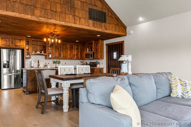 living room with light wood-type flooring, sink, wood ceiling, and an inviting chandelier