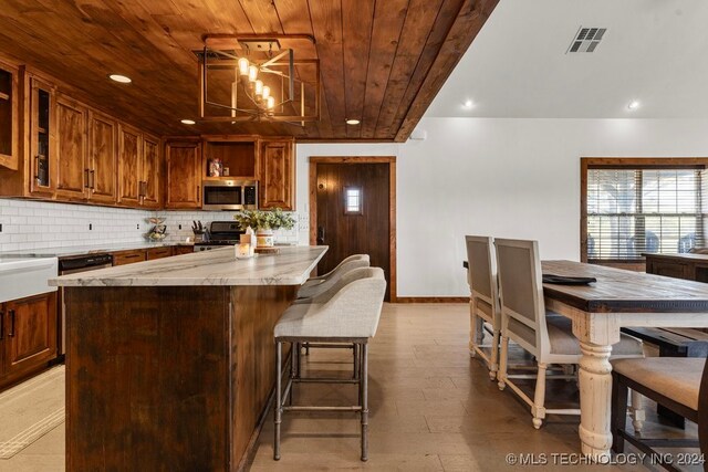 kitchen featuring black range, wood ceiling, decorative backsplash, light stone countertops, and a center island