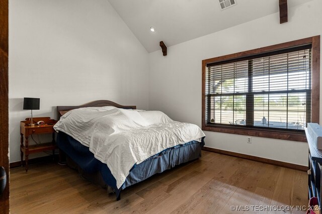 bedroom with wood-type flooring and vaulted ceiling